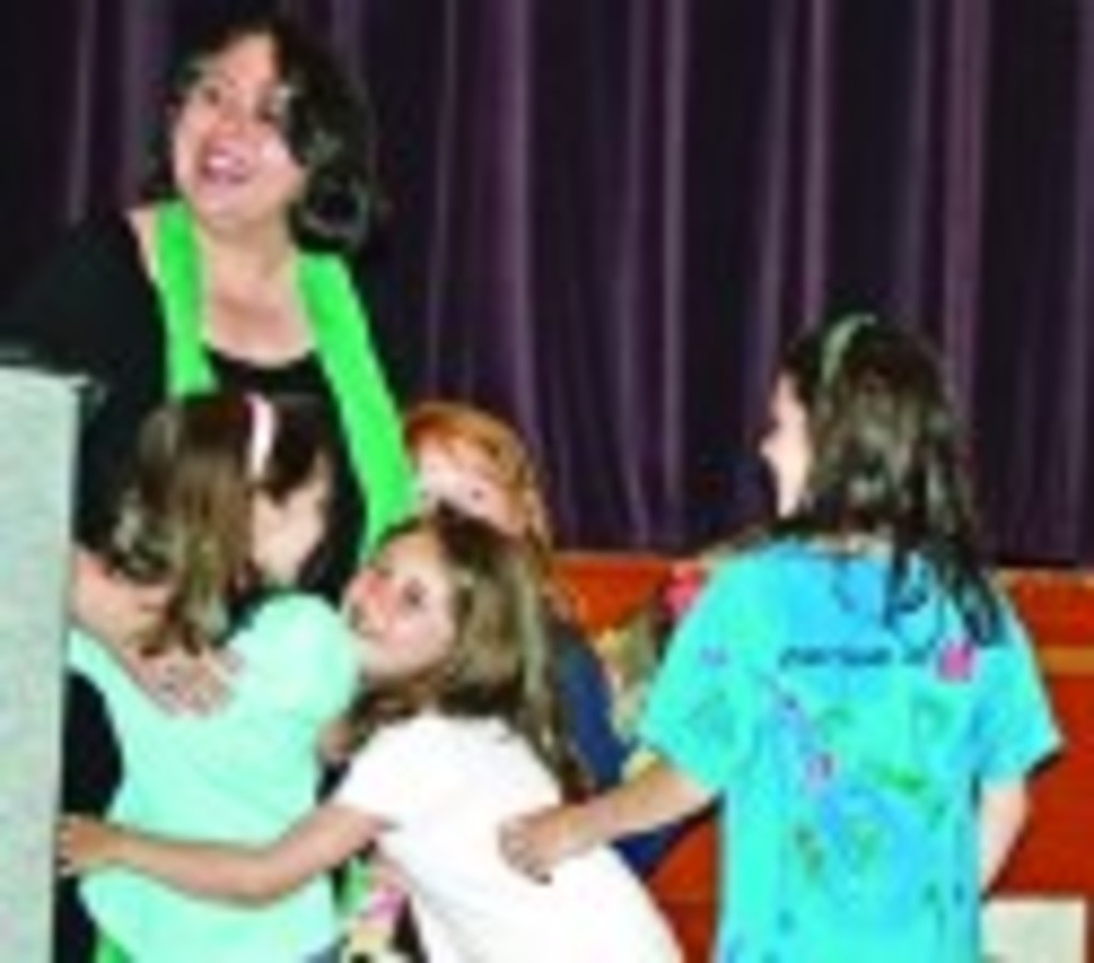 Students from the Jewish Community Day School of Rhode Island embrace Ilana Kapoch after she receives the Lea Eliash Memorial – Grinspoon/Steinhardt Award at the Alliance annual meeting. /NANCY KIRSCH
